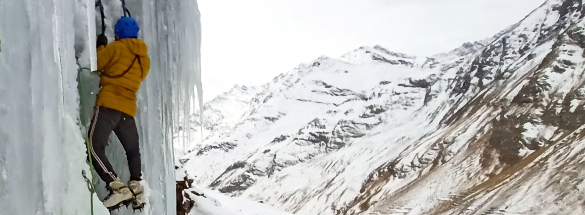 Umesh Raina climbs an ice wall while wearing mountaineering boots equipped with an ice axe and crampons in bara shigri