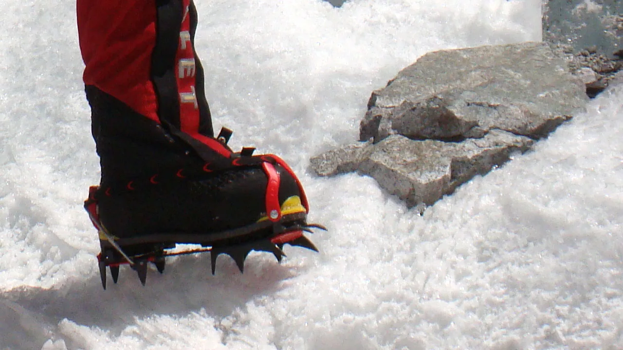 Millet black and red mountaineering boots with crampons for glacier training