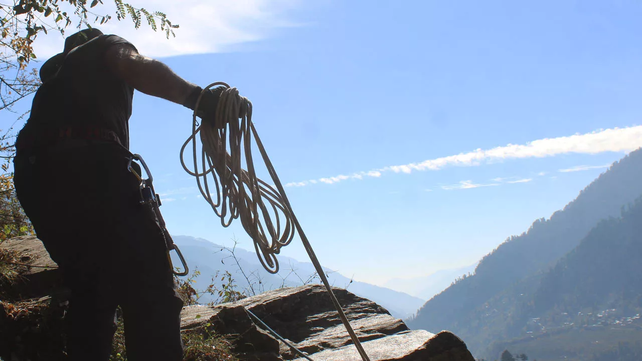 Climber holding rope for setting up an anchor