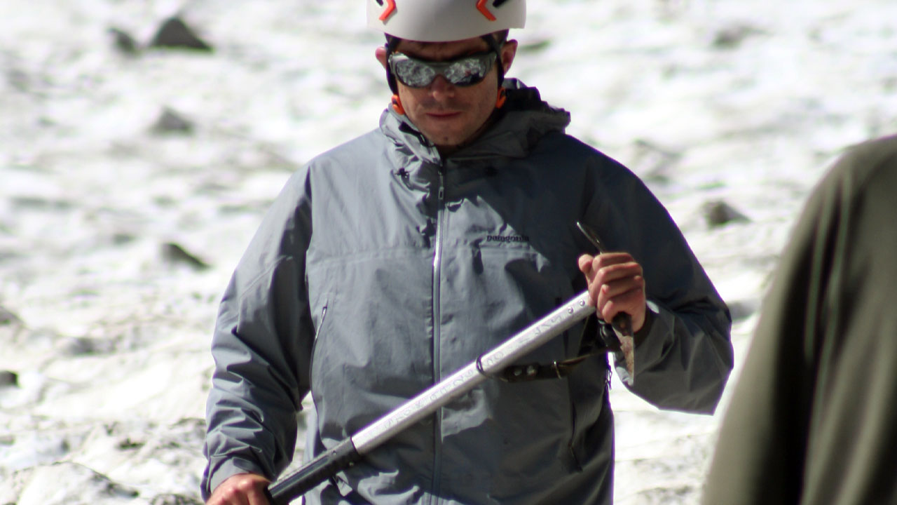 On a ice climbing skills course, a trainee with an ice axe is in self-arrest position