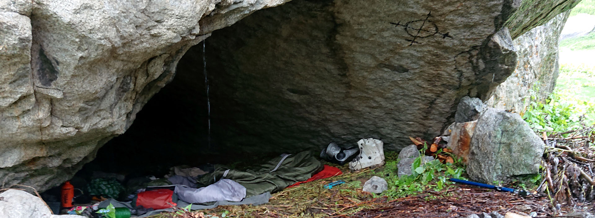 During a survival skill training, participants climb gear that is laying under a rock cave
