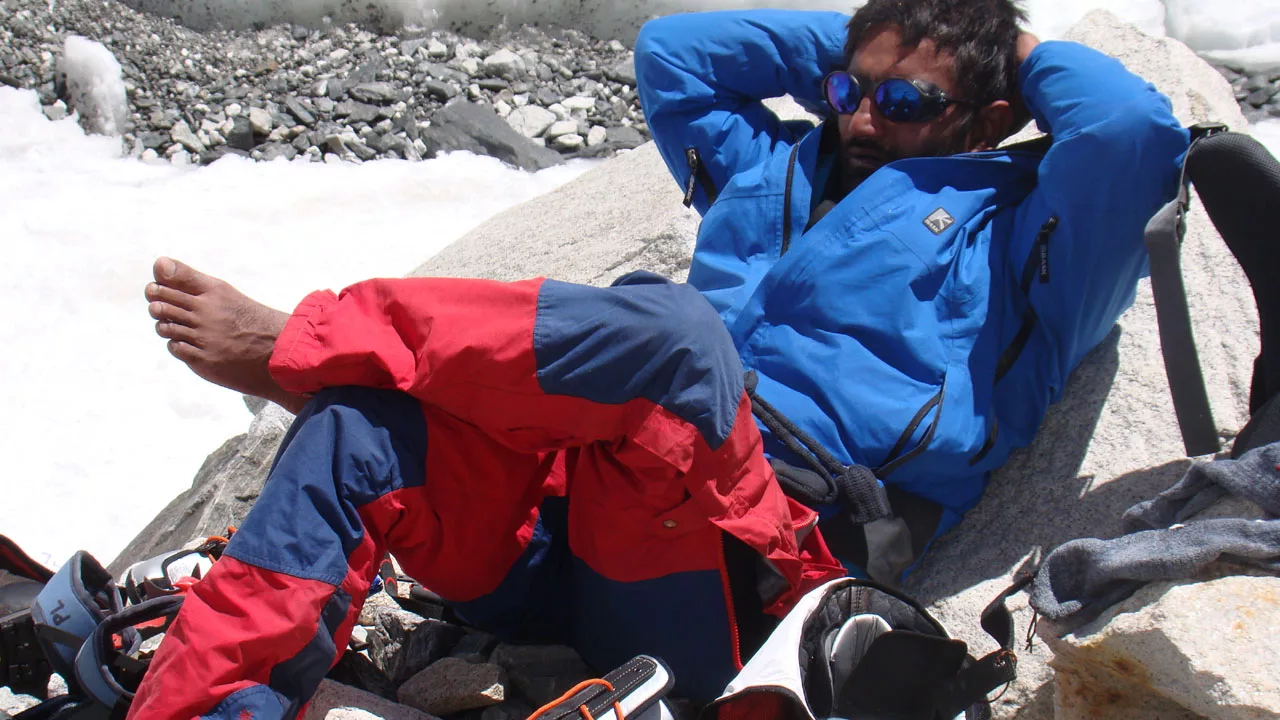 Pankaj Lagwal relaxing on a glacier with his feet exposed to sunlight