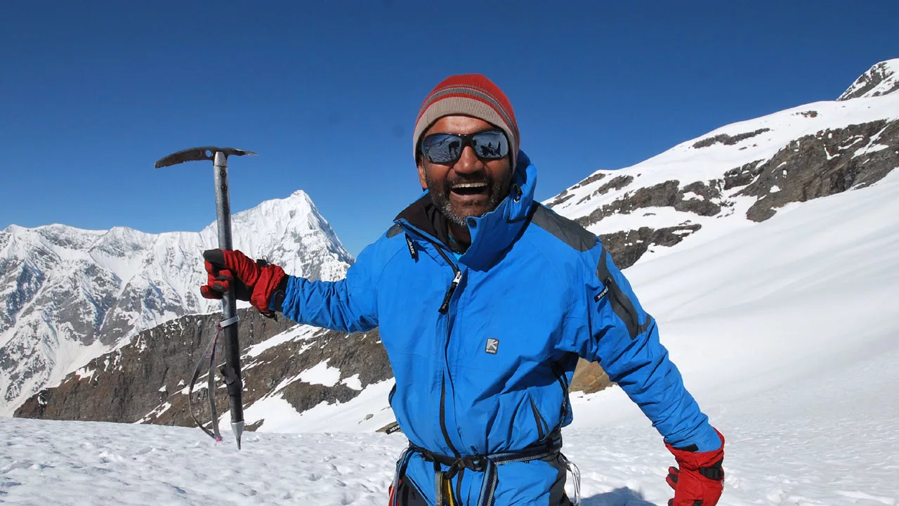 Pankaj lagwal, a mountain guide, smiles broadly while holds an ice axe on the summit of Mt Shiti Dhar.