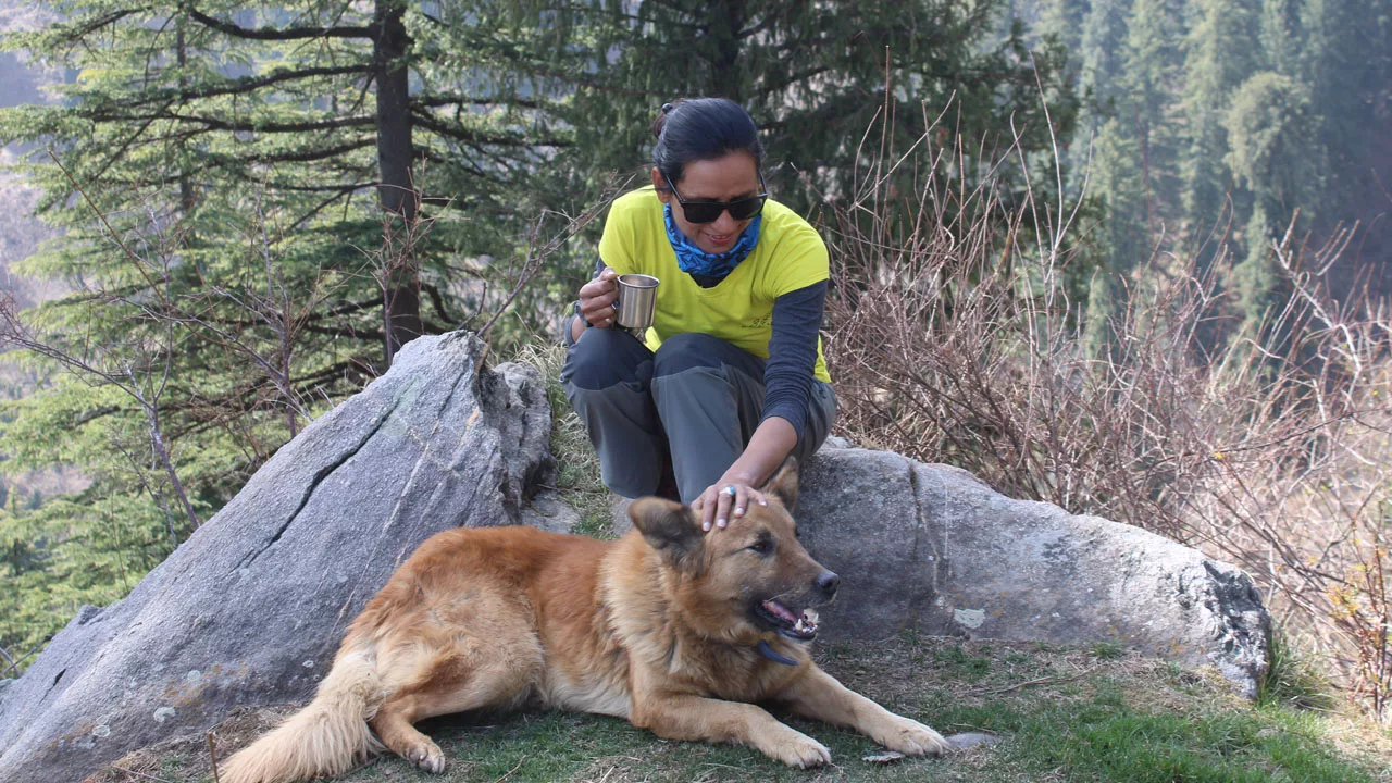 mountain guide shashi lagwal with her dog on a mountain trek