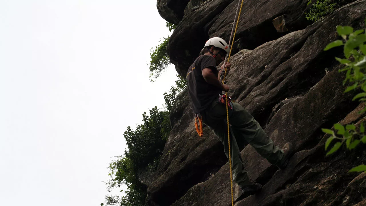 Pankaj Lagwal rappelling down on the rock face during rock climbing training 