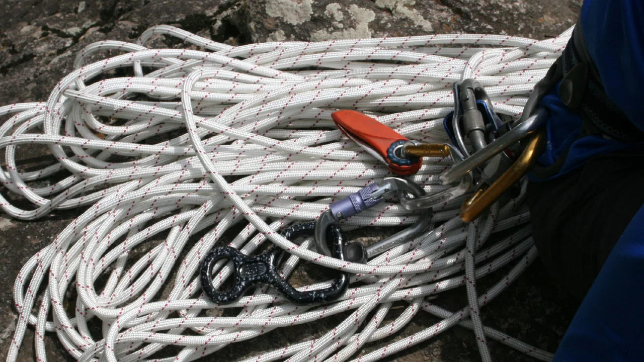 White rope on the rock with climbing tools on top