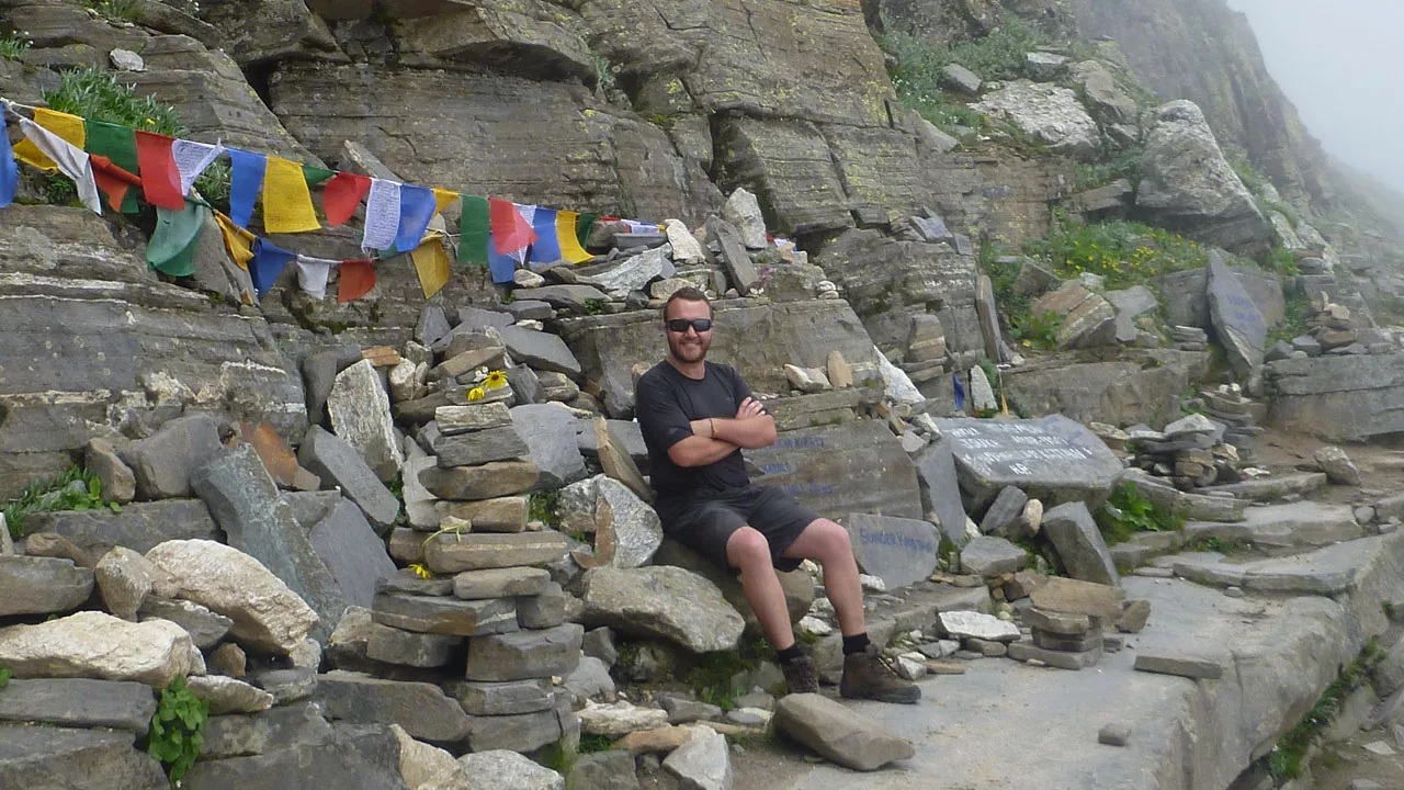 client posing for picture on Hampta pass a moderate trekking trail of himachal