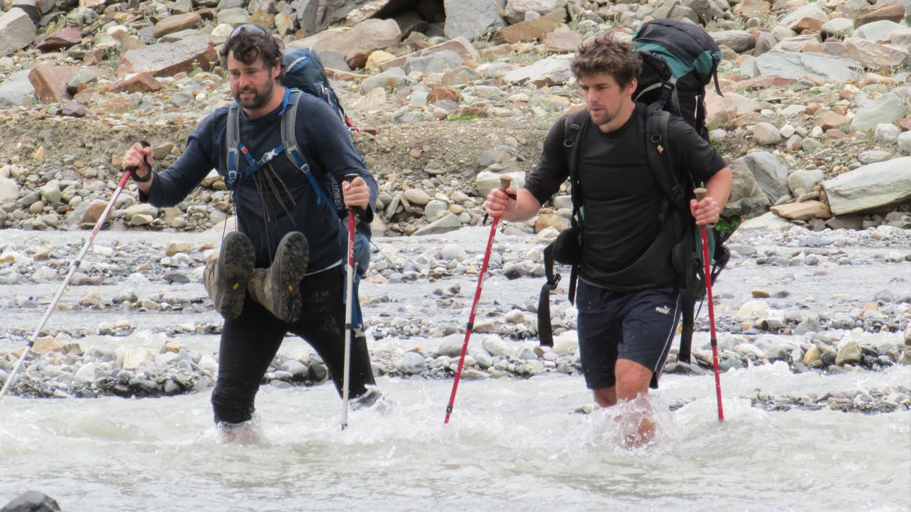 The faces of clients crossing the Pin River during the Pin Parvati Pass a Strenuous Trek in Himachal Pradesh indicate the difficulty of the Pin Parvati Trek