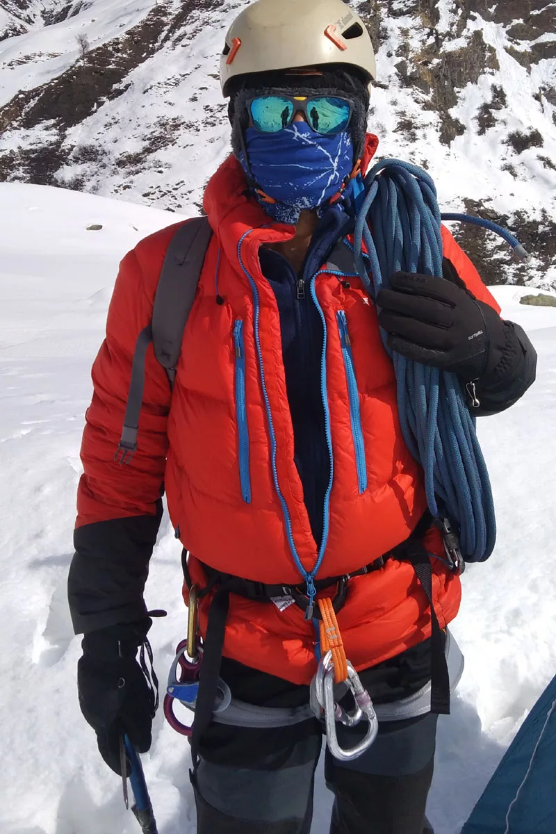 Trainee is prepared to ascend with a rucksack and rope on his shoulder harness, a carabineer around his waist, and an ice axe in his hands.