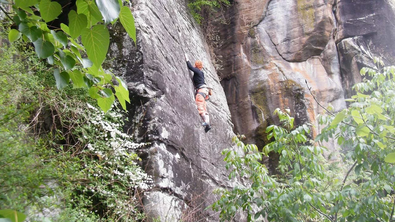 person climbing on a rock cliff 