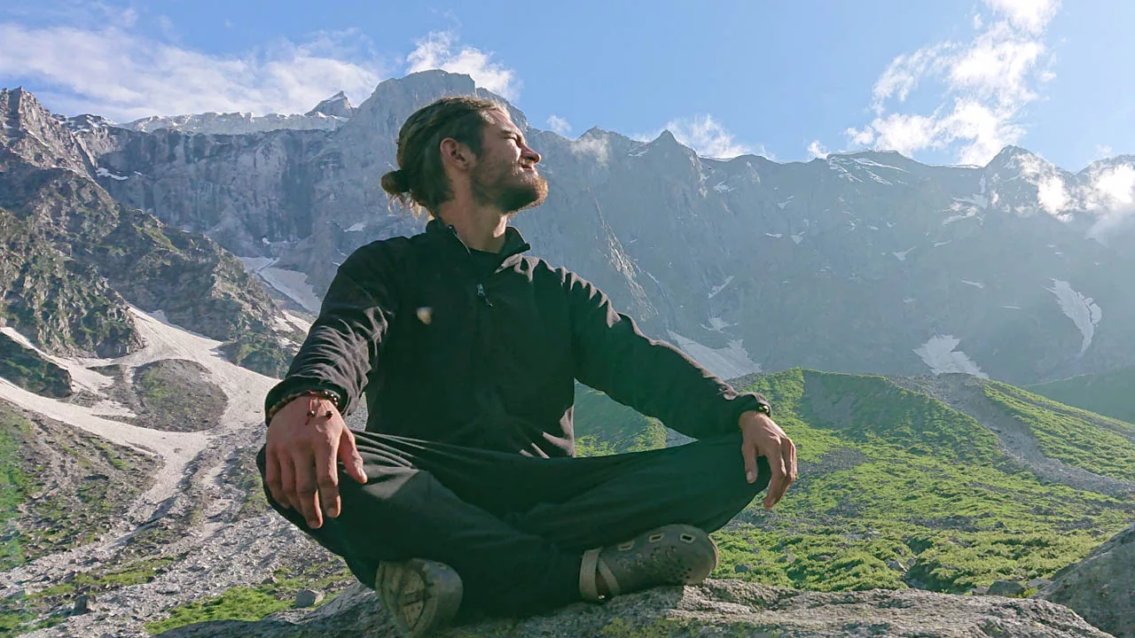 A client meditates on a mountain