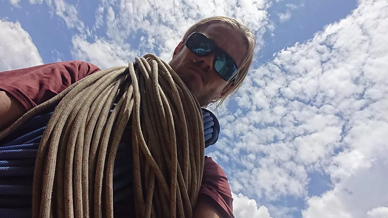 An alpinist with ropes around his neck 