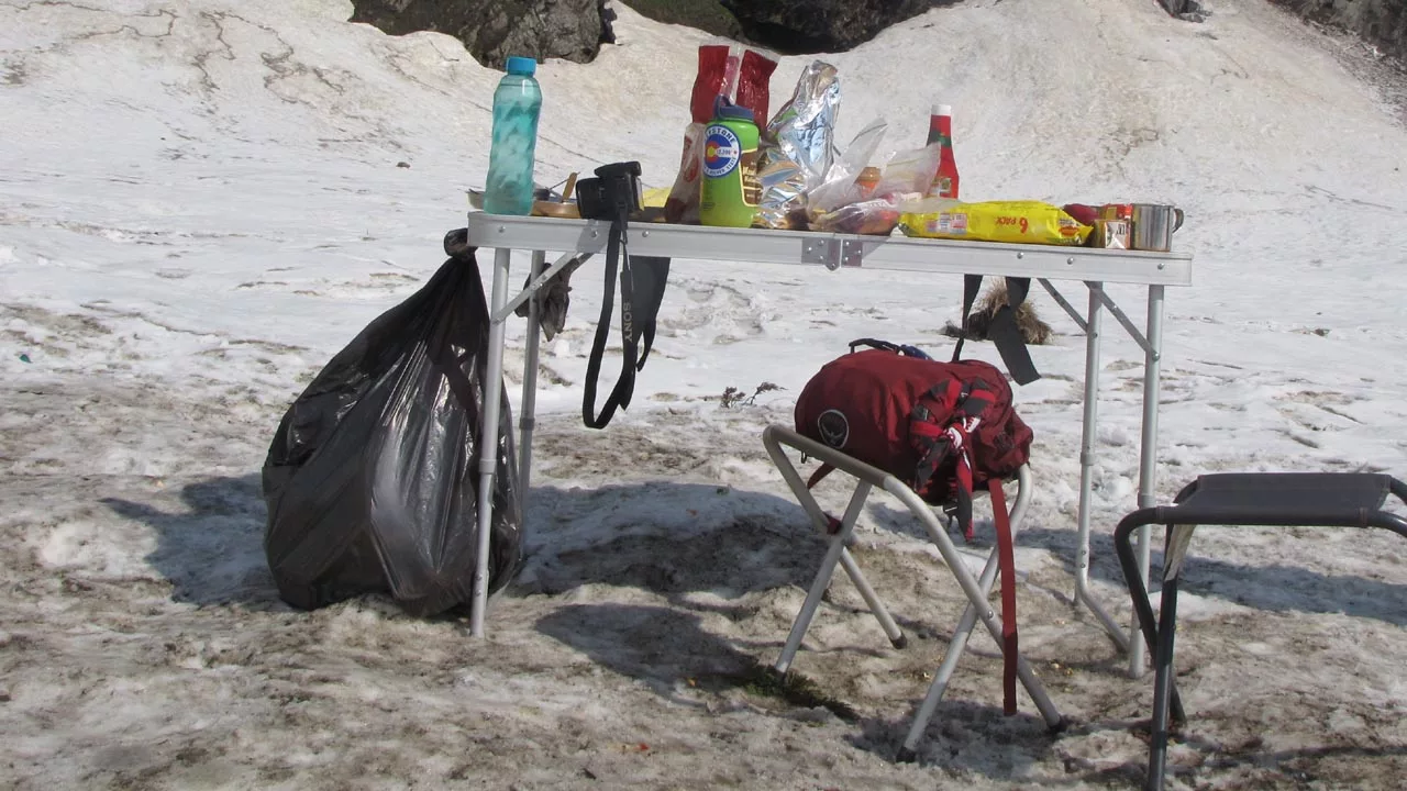 Trash bag tied to a dinner table on Glacier Dispose of Waste Properly LNT