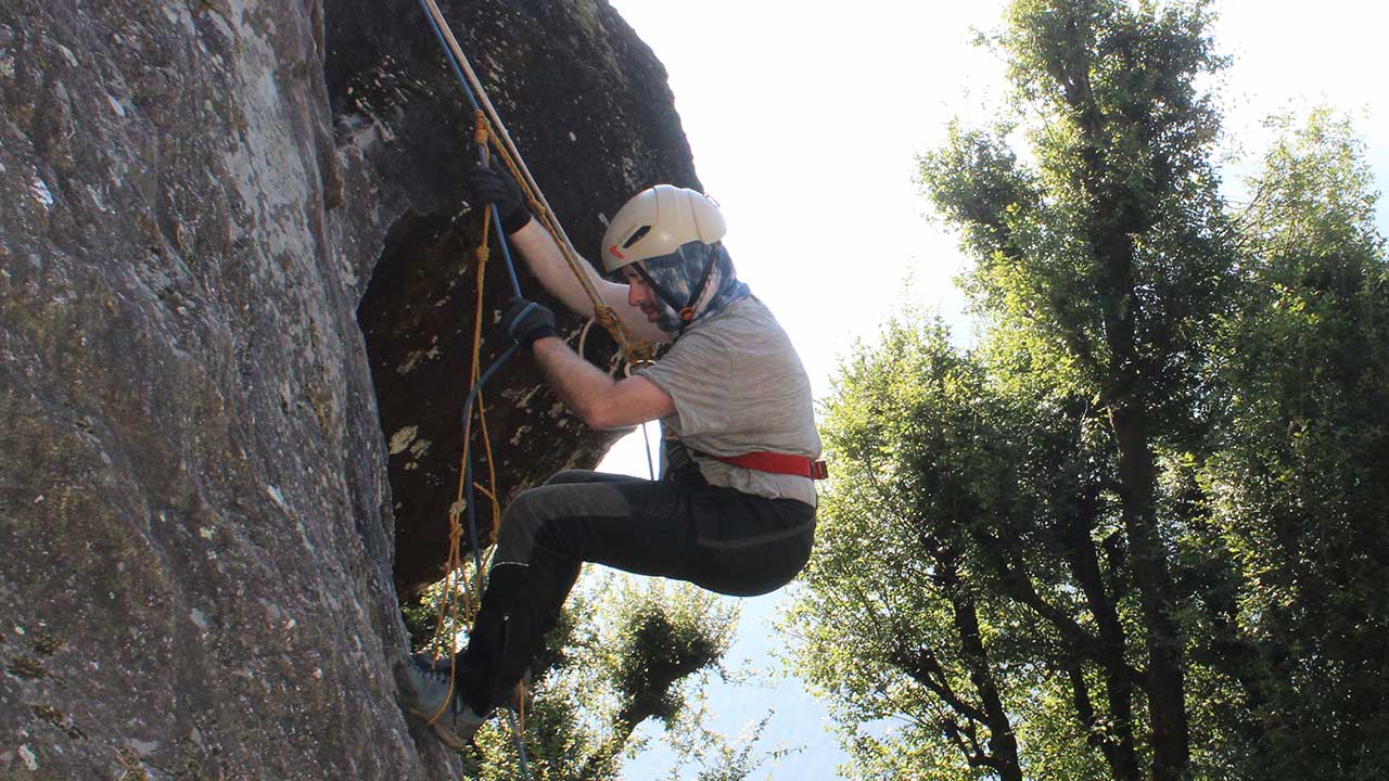 person climbing rock with prusik knot 