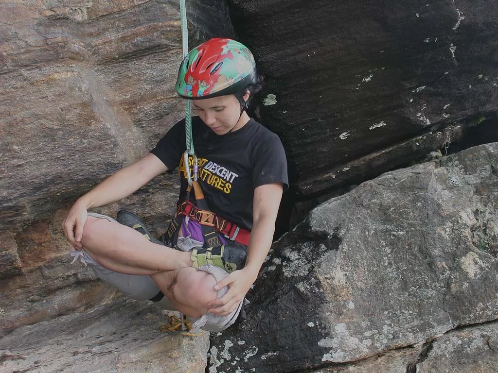 girl meditating in lotus position while Bouldering