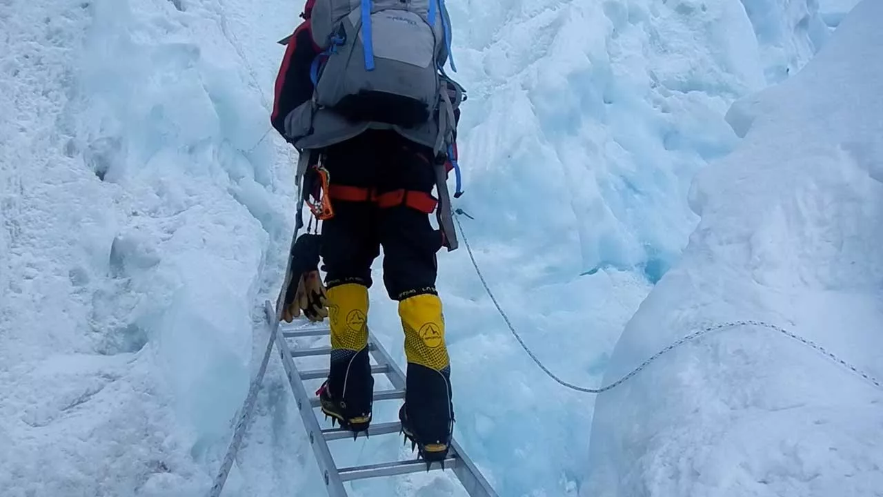 Mountaineer crossing a ladder on the Khumbu Glacier to Everest